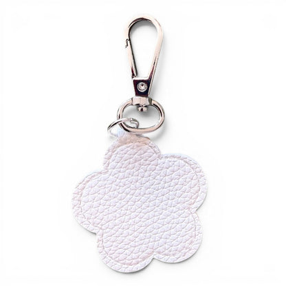 A white faux leather flower-shaped keychain charm with a textured pebbled finish, attached to a silver metal swivel clasp and split ring, shown on a plain white background.